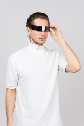 Young man adjusting his futuristic eyewear