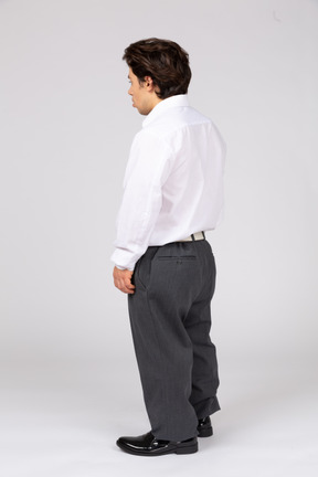 Three-quarter back view of a young office worker looking away