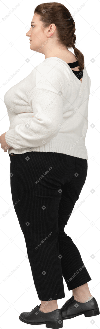 엉덩이에 손을 포즈 흰색 스웨터에 통통한 여자