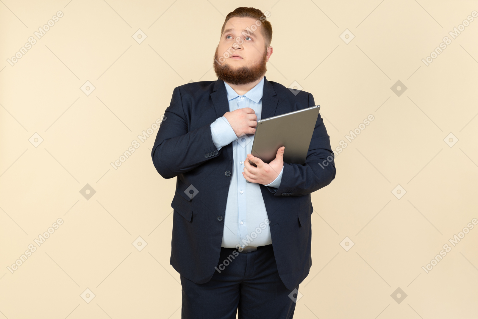 Dreamy looking young office worker holding digital tablet