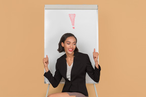 Jolie femme afro assis devant le tableau blanc