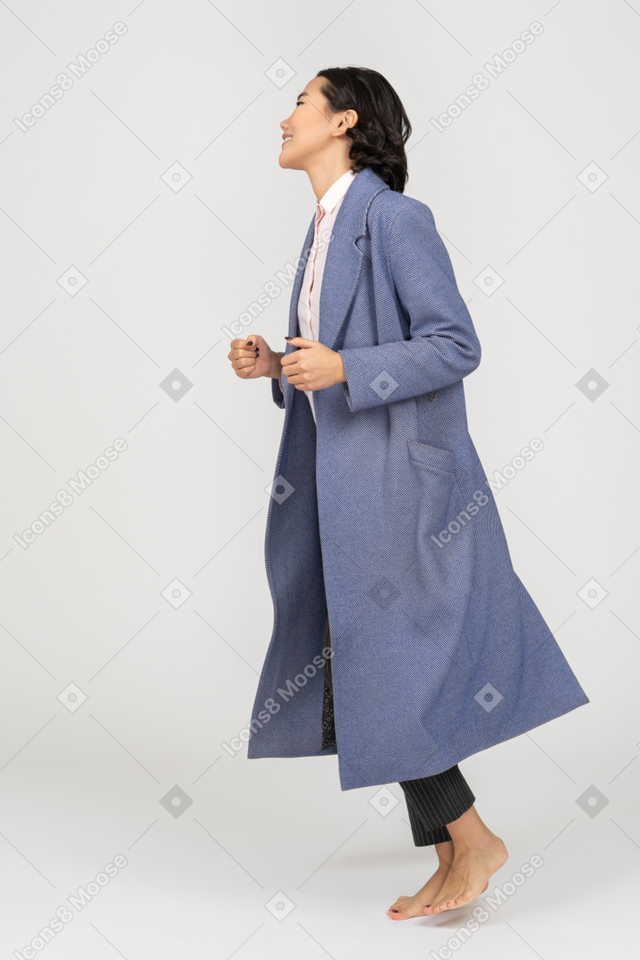 走っているコートを着た笑顔の女性