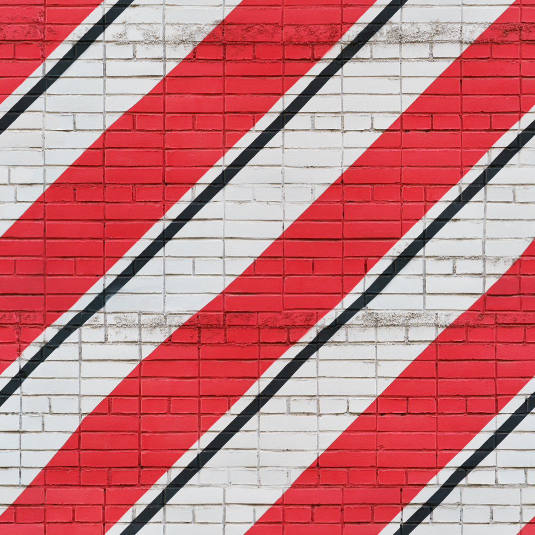 White bricks wall with red and black stripes