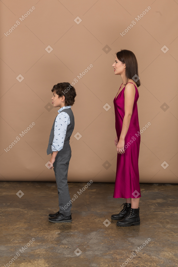 프로필에 서 있는 젊은 여자와 어린 소년