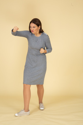 一个穿着灰色裙子的愤怒女人的前视图