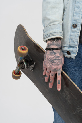 Skateboard in tätowierten händen