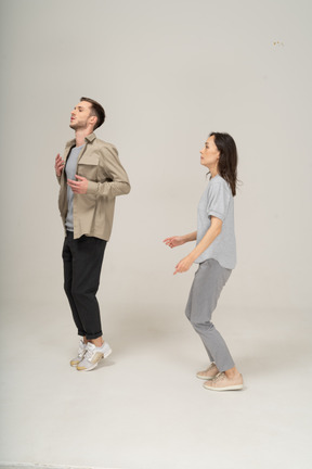 Young man and woman standing on toes