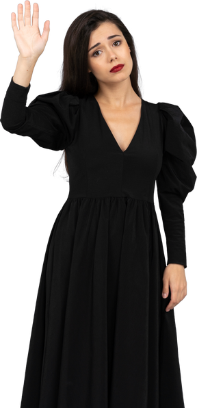 黒いドレスを着た悲しい挨拶の若い女性の正面図