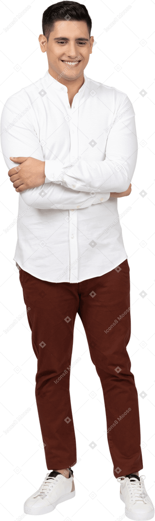 肘を抱えて笑っている若いラテン系男性の正面図