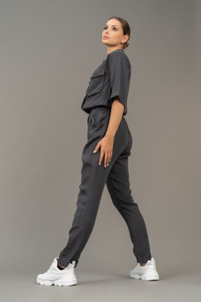 Side view of a bossy young woman in a jumpsuit