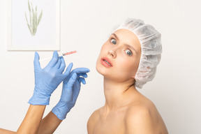 Femme qui a l'air effrayée de se faire injecter du botox