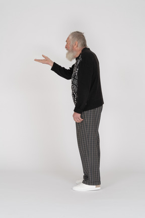 Vista lateral de un anciano de pie y sosteniendo su mano
