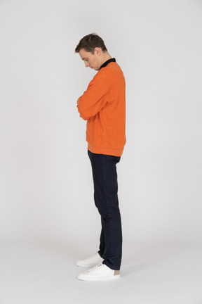 Junger mann im orangefarbenen sweatshirt stehend