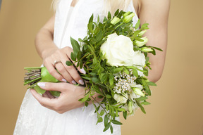 Bride with a ring on a hand holding wedding bouquet