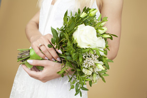 Novia con un anillo en una mano con ramo de boda