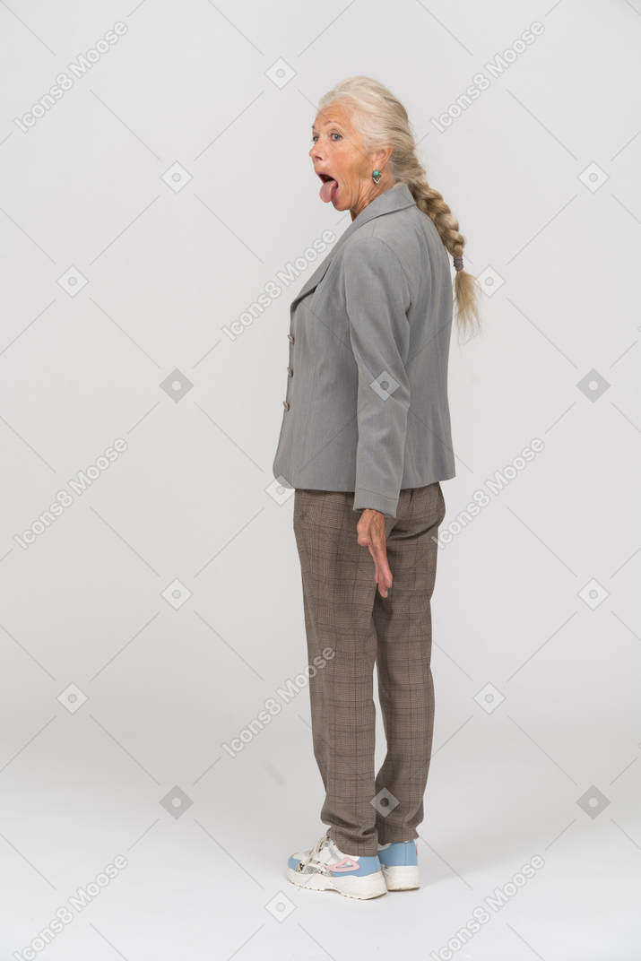 Vista traseira de uma senhora idosa de terno mostrando a língua