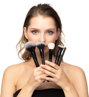 Vue de face d'une jeune femme sensuelle tenant des pinceaux de maquillage