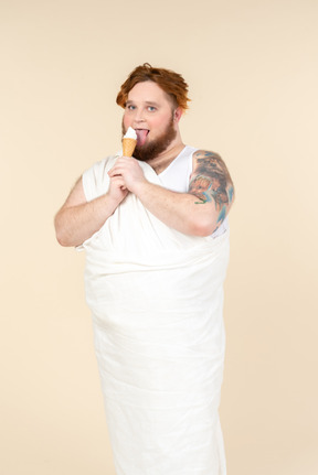 Hombre grande vestido como un cupido comiendo helado