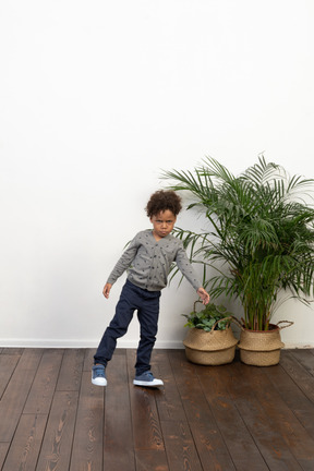 A boy standing on one feet.