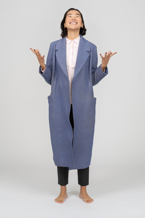 Femme souriante en manteau bleu gesticulant