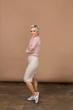 Side view of a happy woman in casual clothes looking at camera