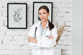 A female doctor standing in front of a brick wall