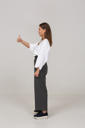 一位身着办公室服装的年轻女士竖起大拇指的侧视图