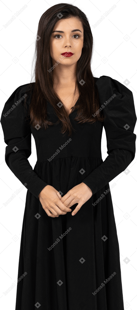 Vue de face d'une jeune femme vêtue d'une robe noire immobile