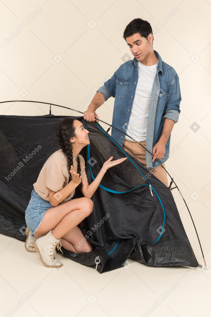 Молодая межрасовая пара возле черной палатки