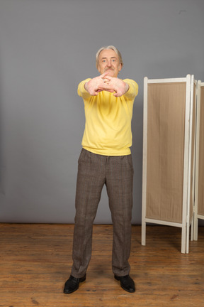 Front view of an old man stretching his arms