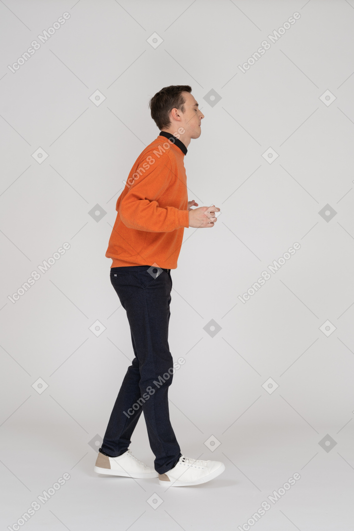 Jovem em moletom laranja posando