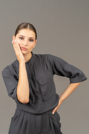 Front view of a young woman in a jumpsuit removing make-up