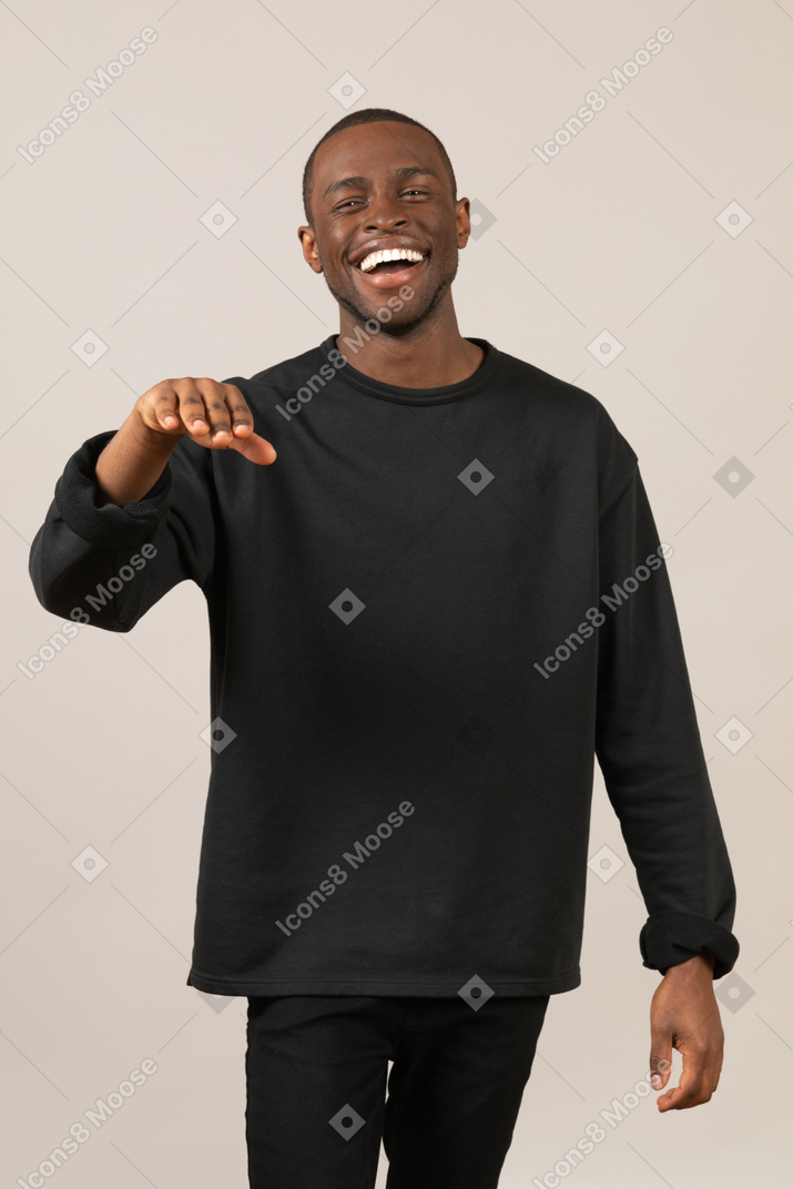 Young man laughing and raising hand