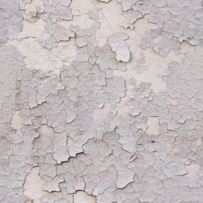 Ancienne couche de peinture fissurée sur mur de béton