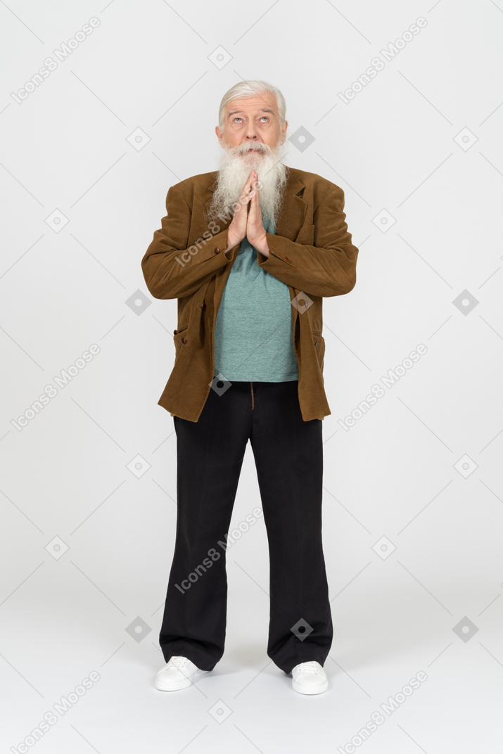 Front view of an elderly man praying with hands folded