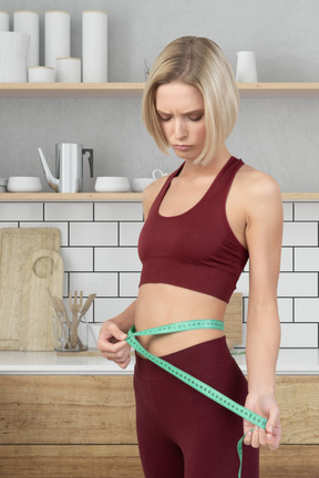A woman measuring her waist with a tape