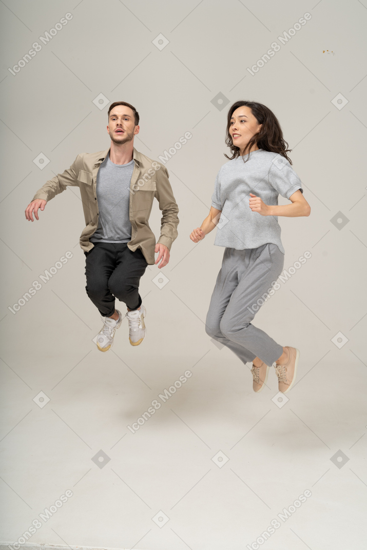 Excited young woman and man jumping