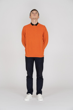 Young man in orange sweatshirt standing