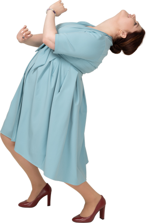 Side view of a woman in blue dress dancing