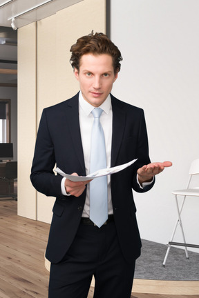 A man in a suit holding a piece of paper