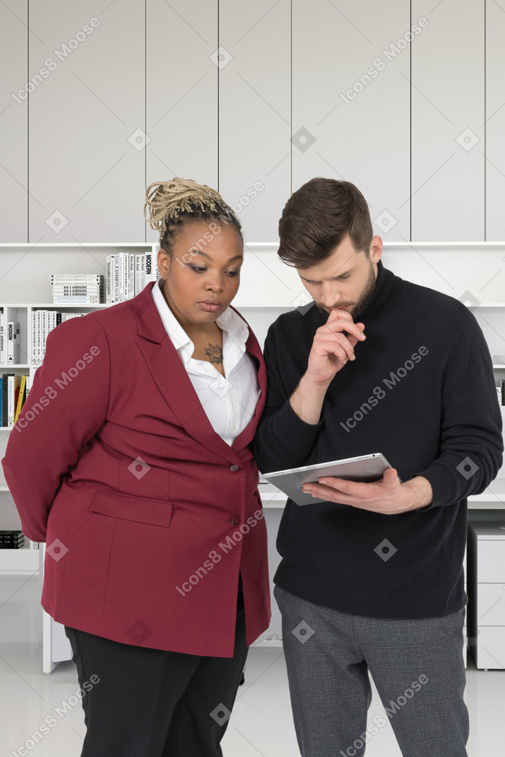 A man and woman looking at something on a tablet