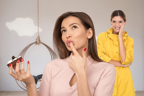 A woman standing next to another woman holding a piece of cake