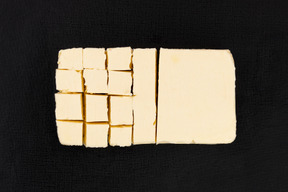 Cortar bloque de mantequilla sobre fondo negro