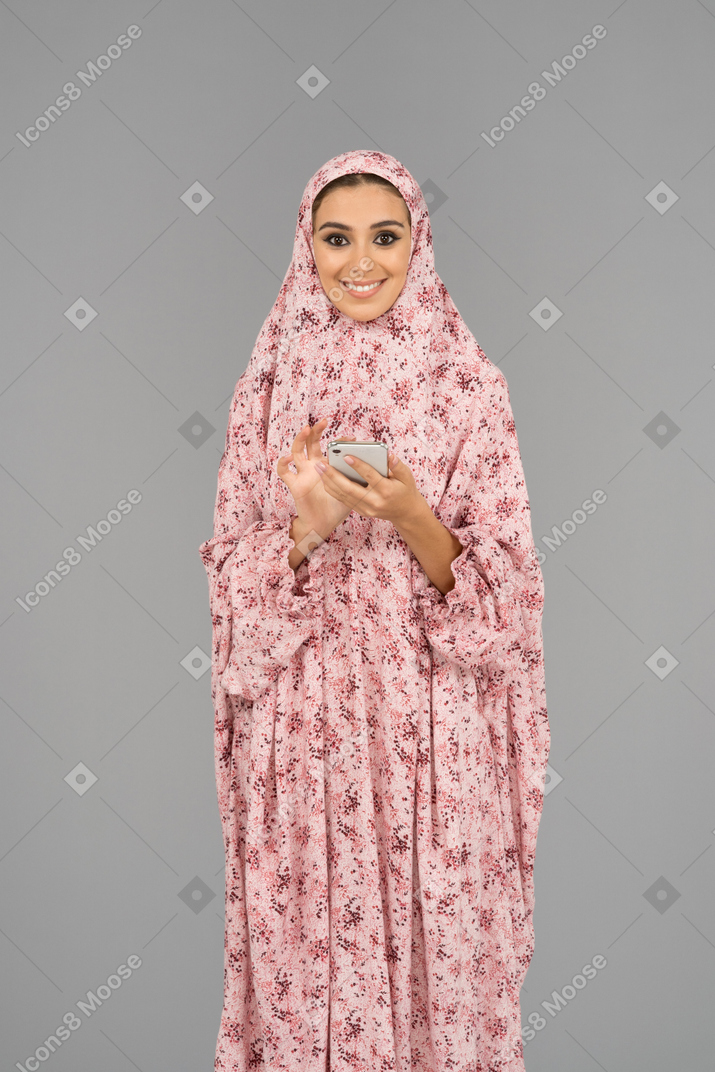 Cheerful covered woman with mobile phone