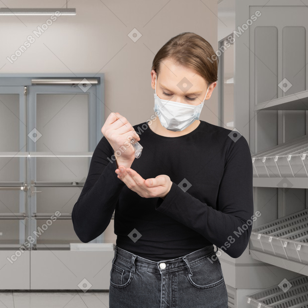 Woman in face mask applying hand sanitizer in a store