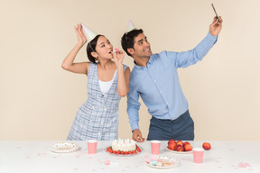 Jovem casal interracial fazendo um selfie ao comemorar aniversário