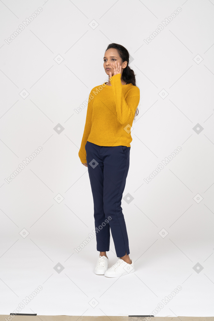 Front view of a girl in casual clothes standing with raised hand
