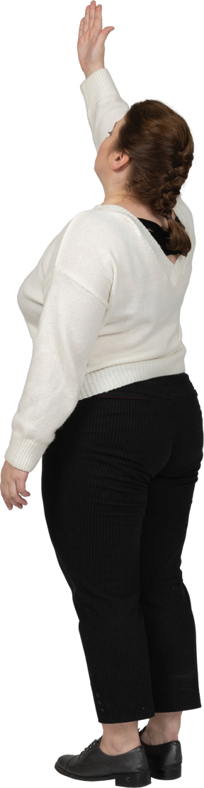Rear view of a plus size woman in casual clothes with raised arm