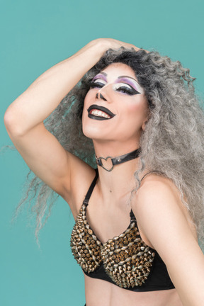 Close-up of a drag queen smiling with hand on head