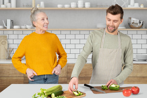 A man preparing food with an older woman